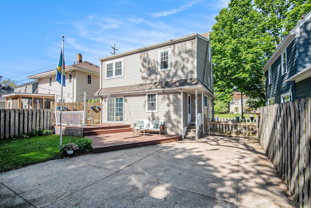 back of property with a fenced backyard and a wooden deck