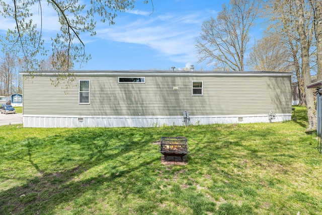 6922 Knotty Pine St NE, Rockford, MI 49341 - back of property featuring a fire pit and a lawn