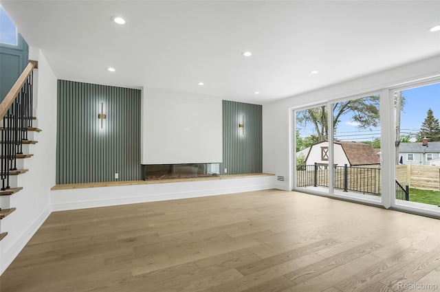 4112 Elmhurst Ave, Royal Oak, MI 48073 - unfurnished living room featuring stairs, wood finished floors, baseboards, recessed lighting, and a glass covered fireplace