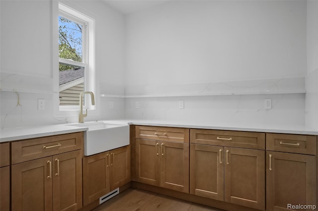 4112 Elmhurst Ave, Royal Oak, MI 48073 - kitchen featuring a sink, light wood-type flooring, brown cabinets, and light countertops