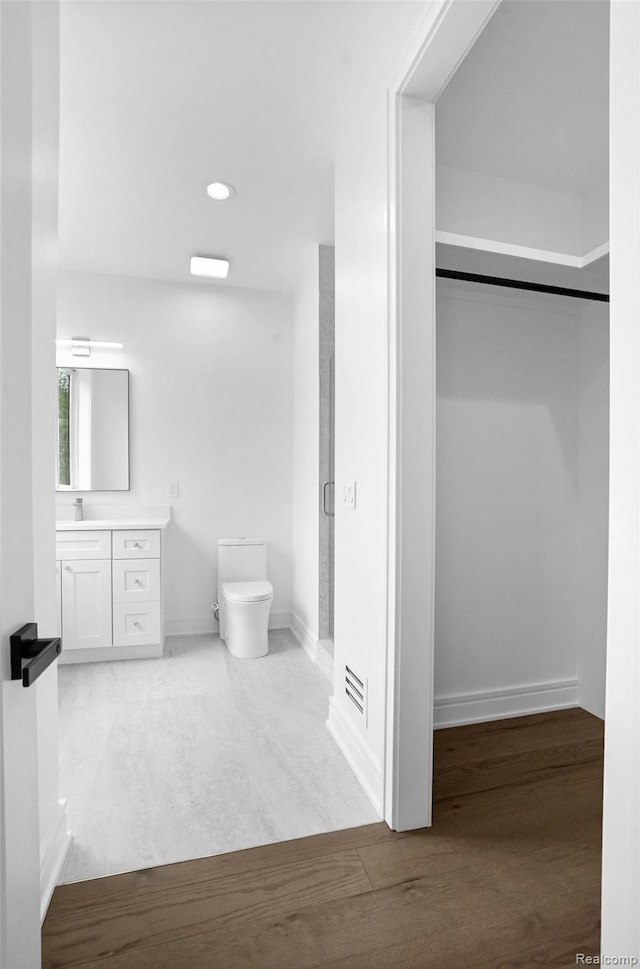 4112 Elmhurst Ave, Royal Oak, MI 48073 - full bathroom featuring vanity, toilet, a spacious closet, baseboards, and wood finished floors