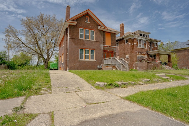 view of front facade with brick siding and a chimney