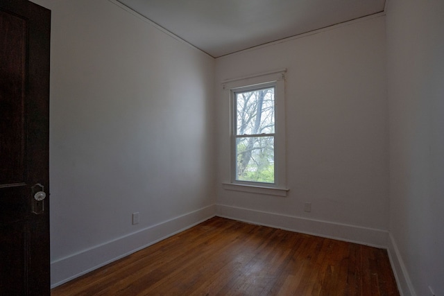 empty room featuring dark wood-type flooring and baseboards