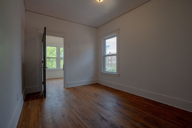 spare room with wood-type flooring and baseboards
