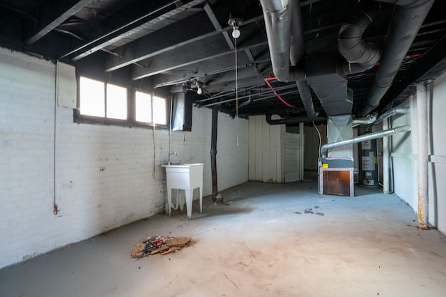 below grade area with water heater, a sink, and heating unit