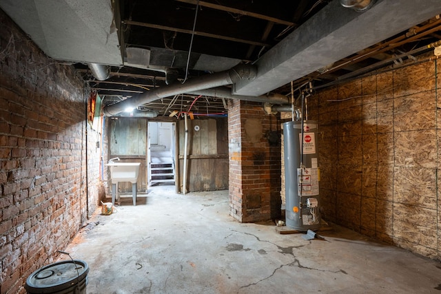 unfinished below grade area featuring water heater and a sink