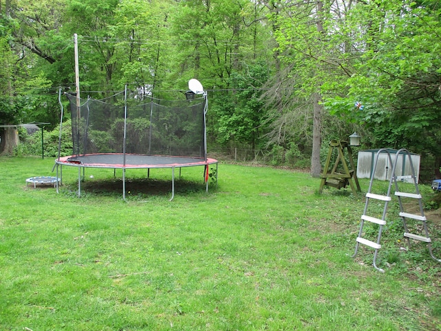 7140 Ridgedale Ln, Lambertville, MI 48144 - view of grassy yard featuring a trampoline and a wooded view