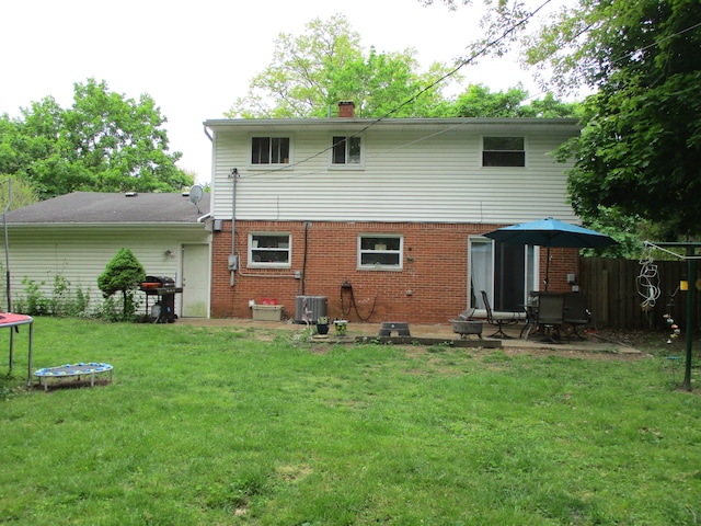 7140 Ridgedale Ln, Lambertville, MI 48144 - back of property with a trampoline, brick siding, a chimney, a patio, and cooling unit