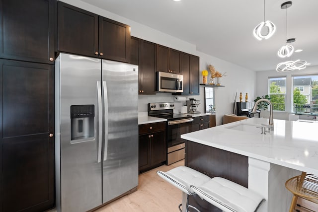 1071 N Sherman Dr Unit B, Royal Oak, MI 48067 - kitchen featuring appliances with stainless steel finishes, light wood-style floors, a sink, pendant lighting, and dark brown cabinetry
