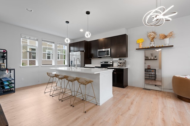 1071 N Sherman Dr Unit B, Royal Oak, MI 48067 - kitchen with stainless steel appliances, light wood-style flooring, a kitchen breakfast bar, light countertops, and recessed lighting