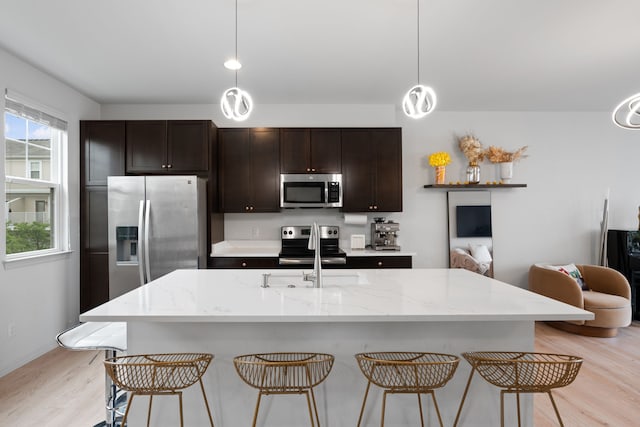 1071 N Sherman Dr Unit B, Royal Oak, MI 48067 - kitchen featuring stainless steel appliances, light wood-style flooring, a breakfast bar area, and a sink