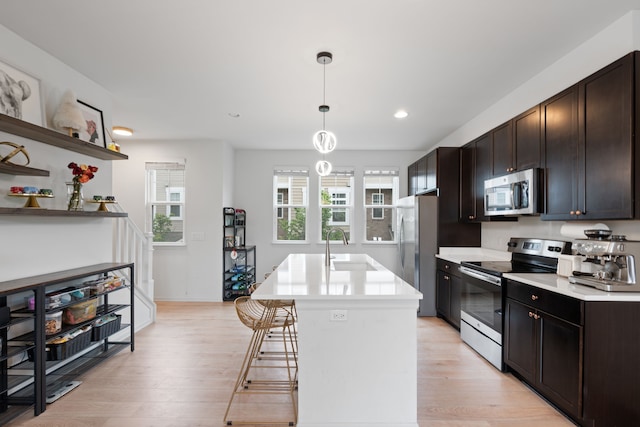 1071 N Sherman Dr Unit B, Royal Oak, MI 48067 - kitchen with stainless steel appliances, a sink, light countertops, a kitchen island with sink, and light wood finished floors