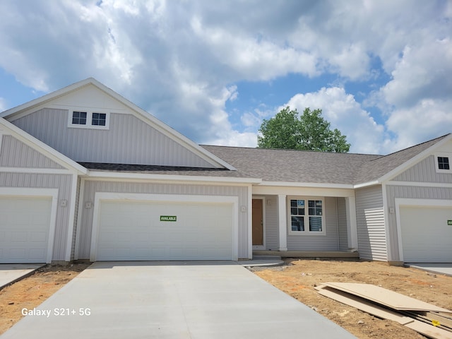 1535 N Village Cir, Kalamazoo, MI 49009 - townhome / multi-family property featuring roof with shingles, driveway, a garage, and board and batten siding