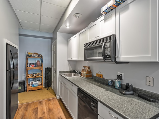 3097 Lansdowne Rd, Waterford, MI 48329 - kitchen featuring black appliances, a sink, light wood-type flooring, a drop ceiling, and white cabinetry