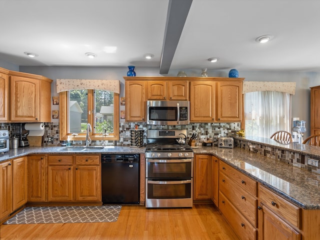 3097 Lansdowne Rd, Waterford, MI 48329 - kitchen featuring stainless steel appliances, a sink, light wood-style floors, decorative backsplash, and beam ceiling