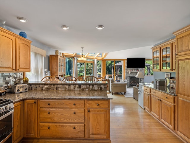 3097 Lansdowne Rd, Waterford, MI 48329 - kitchen featuring a fireplace, plenty of natural light, glass insert cabinets, and brown cabinets