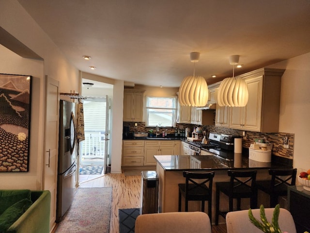 2713 Trowbridge St, Hamtramck, MI 48212 - kitchen featuring stainless steel appliances, a peninsula, a sink, dark countertops, and tasteful backsplash