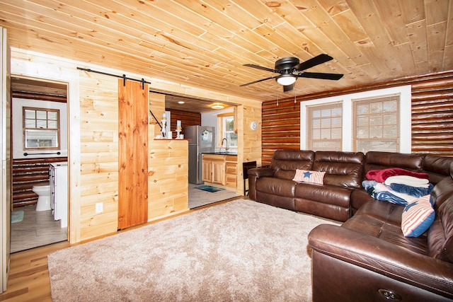 116 Alma Ln, Houghton Lake, MI 48629 - living area with a barn door, wood ceiling, log walls, ceiling fan, and wood finished floors