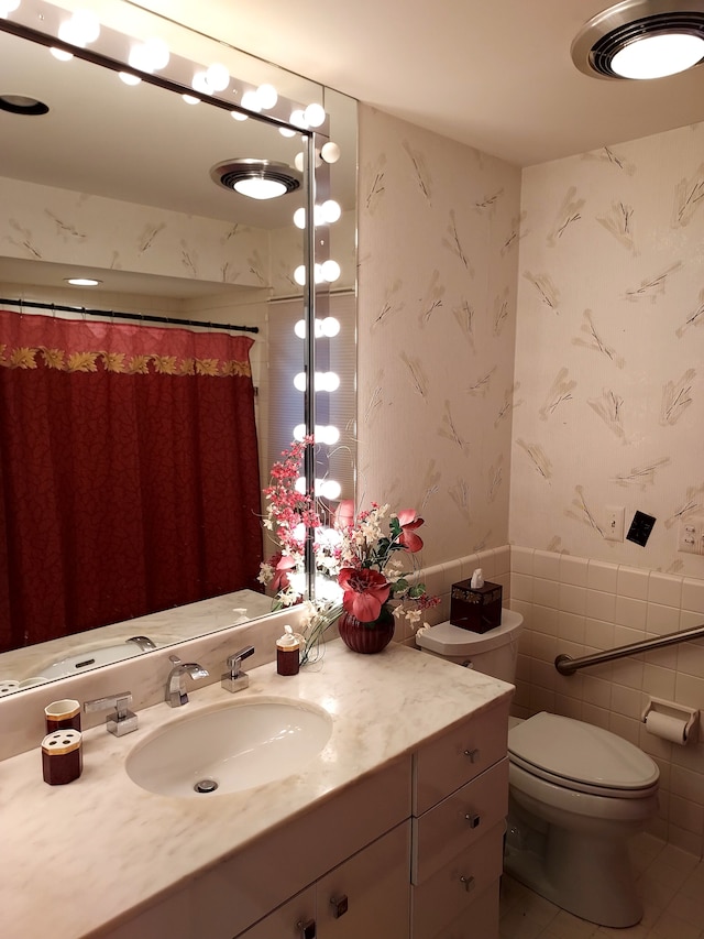 7215 Suncrest Rd, West Bloomfield, MI 48322 - bathroom featuring wallpapered walls, tile walls, vanity, toilet, and a wainscoted wall