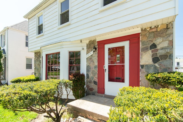 doorway to property featuring stone siding