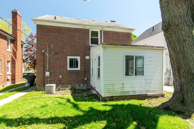 back of property with brick siding and a lawn