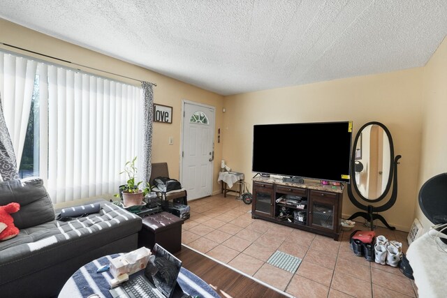 living room with a textured ceiling and light tile patterned floors
