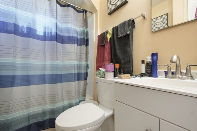full bath with vanity, toilet, and curtained shower