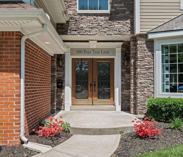 680 Pear Tree Ln, Grosse Pointe Woods, MI 48236 - view of exterior entry with french doors, stone siding, and brick siding