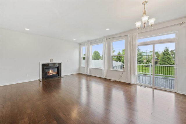 3236 Curtis, Wixom, MI 48393 - unfurnished living room featuring a chandelier, healthy amount of natural light, dark wood-style flooring, a fireplace, and recessed lighting