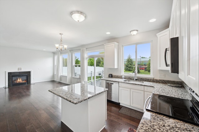 3236 Curtis, Wixom, MI 48393 - kitchen featuring stainless steel appliances, a sink, a center island, a high end fireplace, and white cabinets