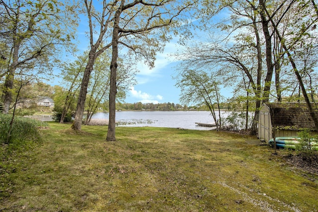 14965 Loon Lake Dr, Bellevue, MI 49021 - view of grassy yard with a water view, a storage unit, and an outdoor structure