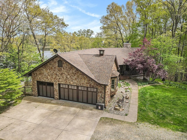 14965 Loon Lake Dr, Bellevue, MI 49021 - view of property exterior featuring stone siding, roof with shingles, concrete driveway, a chimney, and an attached garage