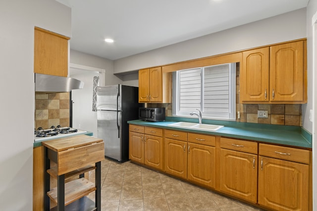 kitchen featuring under cabinet range hood, a sink, stainless steel appliances, backsplash, and light tile patterned floors