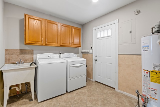 laundry area featuring gas water heater, washer and clothes dryer, cabinet space, electric panel, and light tile patterned floors