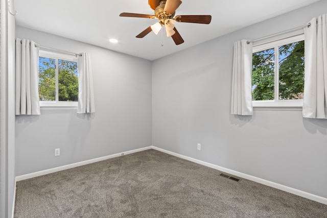 carpeted empty room with healthy amount of natural light, baseboards, and ceiling fan