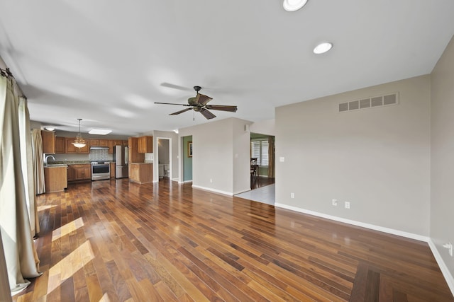 1287 Deer Run, Grass Lake, MI 49240 - unfurnished living room featuring ceiling fan, baseboards, dark wood-style floors, and a sink
