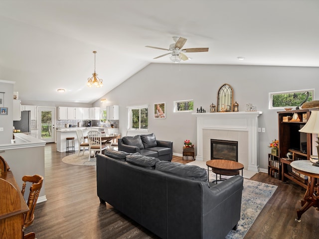 living area featuring a tile fireplace, ceiling fan, dark wood-style floors, and lofted ceiling
