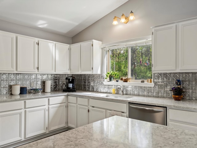 kitchen with dishwasher, lofted ceiling, backsplash, white cabinets, and light stone countertops