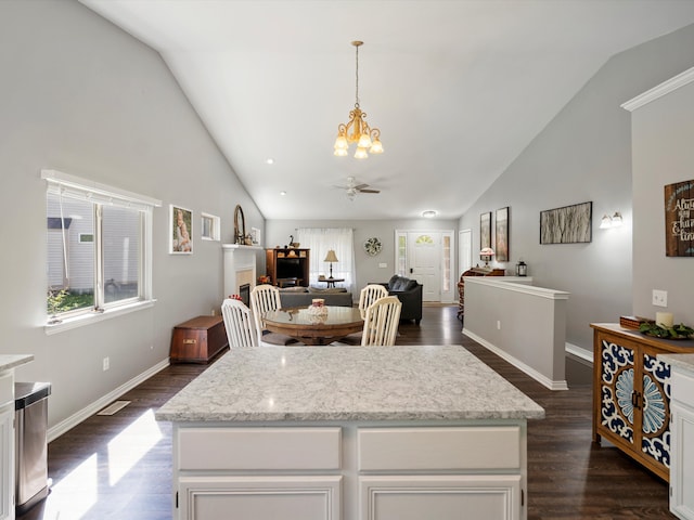 kitchen with a chandelier, high vaulted ceiling, dark wood finished floors, decorative light fixtures, and baseboards