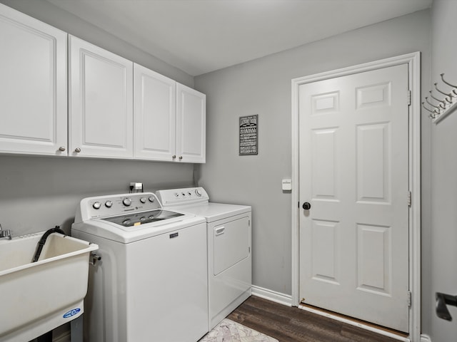 washroom featuring independent washer and dryer, cabinet space, dark wood finished floors, and baseboards