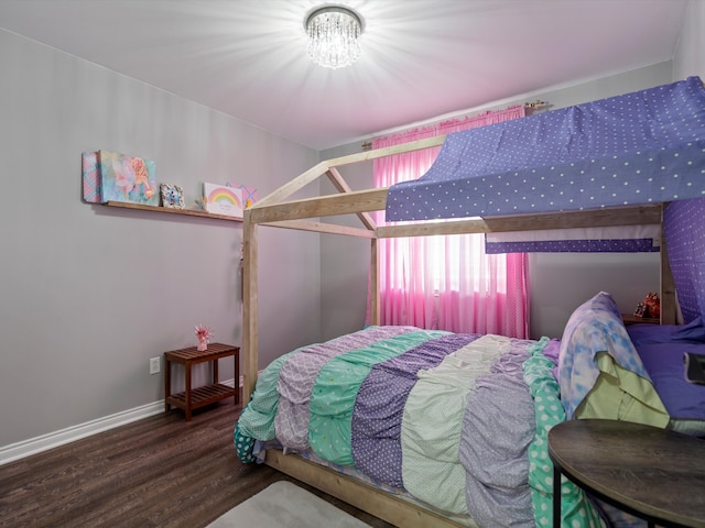 bedroom featuring wood finished floors, baseboards, and a chandelier