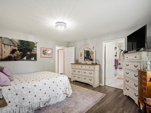 bedroom featuring dark wood finished floors, a chandelier, and ensuite bath