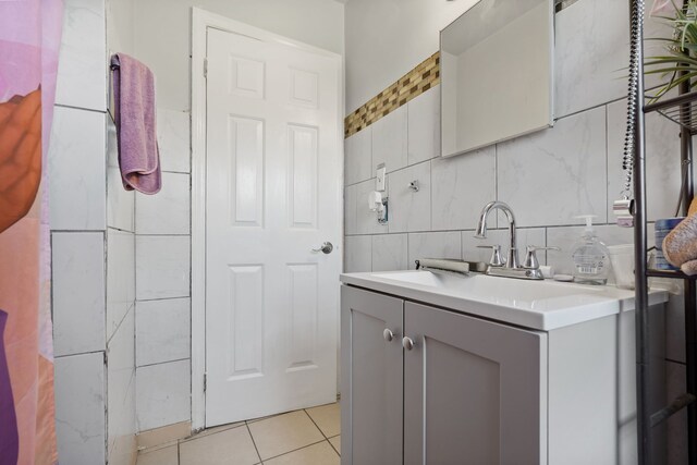 bathroom featuring tile patterned floors, vanity, tile walls, and tasteful backsplash