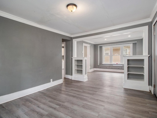 unfurnished living room with crown molding, wood finished floors, baseboards, and recessed lighting