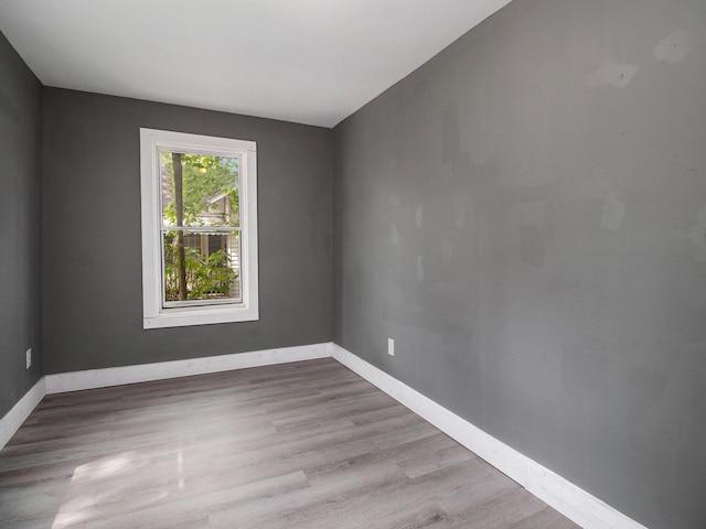empty room with baseboards and wood finished floors