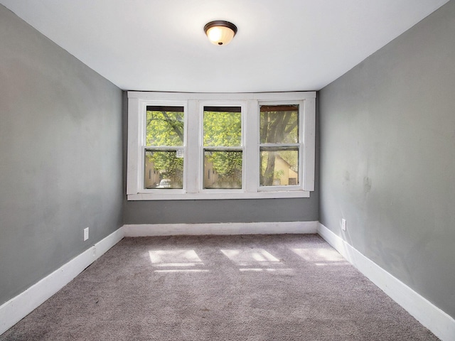 unfurnished room with plenty of natural light, carpet flooring, and baseboards