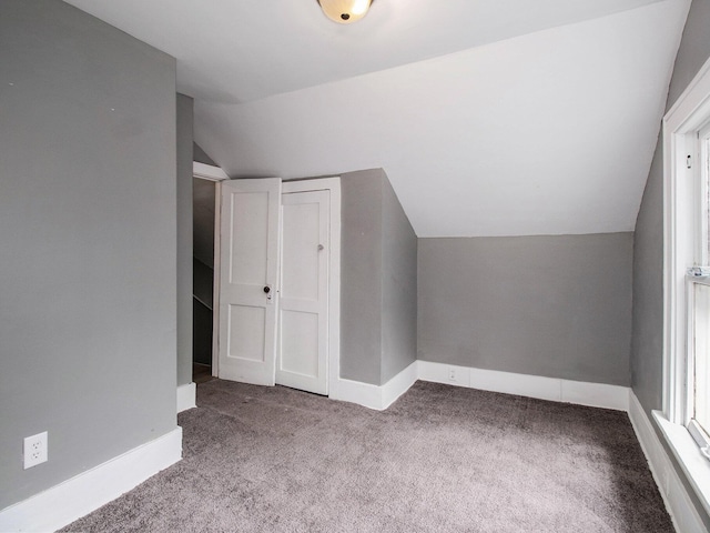 bonus room with carpet flooring, lofted ceiling, and baseboards