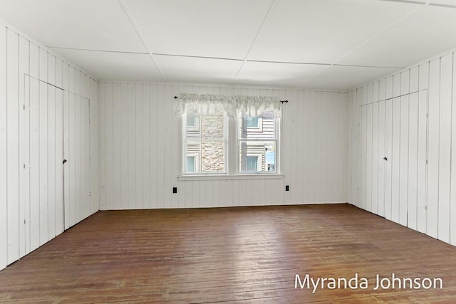 15926 Beach Dr, Spring Lake, MI 49456 - unfurnished bedroom with wood-type flooring, a closet, and wooden walls