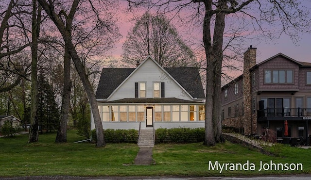 15926 Beach Dr, Spring Lake, MI 49456 - back of house with a sunroom, a yard, and a chimney