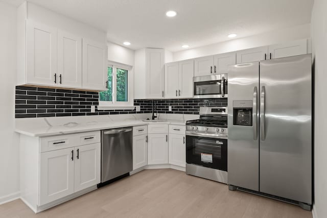 3884 Cass Elizabeth Rd, Waterford, MI 48328 - kitchen featuring stainless steel appliances, light wood-style flooring, light stone counters, white cabinets, and recessed lighting